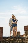 Lächelndes junges Paar, das sich auf dem Dach umarmt — Stockfoto