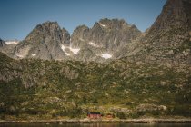 Mountain landscape and log cabin by lake — Stock Photo