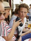 Touristen sitzen mit Kamera im Café nebenan — Stockfoto