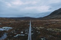 Прямая пустая дорога через луга — стоковое фото