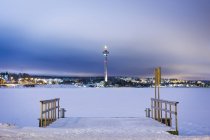 Зимняя сцена с замёрзшим озером и башней связи — стоковое фото