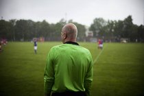 Visão traseira do árbitro em pé no campo de futebol — Fotografia de Stock