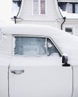 Coche retro blanco cubierto de nieve - foto de stock