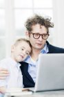 Father and son wearing formal wear using laptop together — Stock Photo