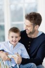 Father and son sitting together and smiling — Stock Photo