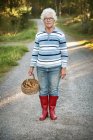 Retrato de la mujer mayor cosechando hongos cantarela - foto de stock