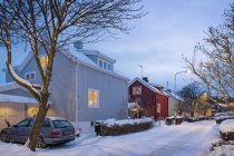 Voiture garée par maison dans un quartier résidentiel en hiver — Photo de stock