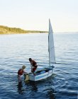 Two boys on sailboat on lake, selective focus — Stock Photo