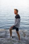 Ragazzo adolescente in piedi sulla roccia da acqua — Foto stock