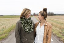 Mother and daughter standing face to face, focus on foreground — Stock Photo