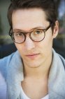 Portrait of young man in eyeglasses, focus on foreground — Stock Photo