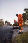 Вид сбоку рабочего, ремонтирующего дорогу — стоковое фото