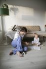 Батько і дитина син сидить на підлозі у вітальні — стокове фото