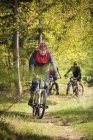 Ältere Männer fahren mit Mountainbikes durch Wald — Stockfoto