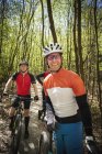 Three mountain bikers in forest — Stock Photo