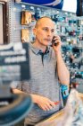 Small business owner of bicycle store talking by smartphone — Stock Photo