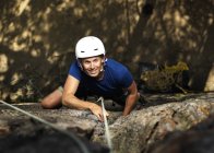 Smiling man climbing rock, selective focus — Stock Photo