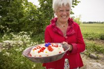 Женщина держит большую миску десерта, сосредоточиться на переднем плане — стоковое фото