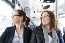Duas mulheres andando de ônibus e olhando para longe — Fotografia de Stock