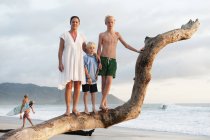 Madre con dos hijos en la playa - foto de stock
