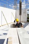 Trabajador de la construcción preparando bloque de construcción para ser levantado - foto de stock