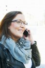 Mulher com cabelo castanho, com óculos a falar ao telefone — Fotografia de Stock