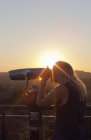 Frau mit Münzfernglas bei Sonnenuntergang in Los Angeles — Stockfoto