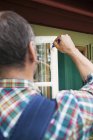 Vue arrière de l'homme préparant fenêtre pour la peinture — Photo de stock