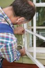 Rear view of man preparing window for painting — Stock Photo