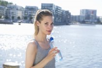 Жінка стоїть з пляшкою води в руках — стокове фото