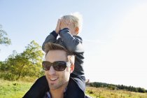Boy covering father eyes, selective focus — Stock Photo