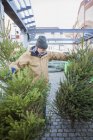 Mature man in warm clothing shopping for Christmas tree — Stock Photo