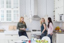 Three women in kitchen, selective focus — Stock Photo