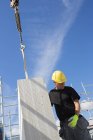 Trabalhador da construção civil preparando bloco de construção a ser levantado — Fotografia de Stock