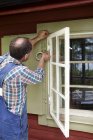 Mann bereitet Fenster zum Malen vor — Stockfoto