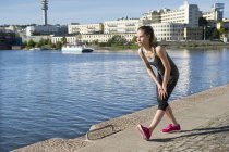 Женщина в спортивной одежде тренируется вдоль набережной — стоковое фото