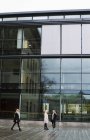 Junge erwachsene Frauen reden an der Glaswand des Universitätsgebäudes — Stockfoto