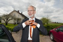 Старший чоловік зав'язує краватку — стокове фото
