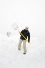 Woman with snow shovel in Vorarlberg, Austria — Stock Photo