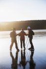 Зрелые люди катаются на коньках по замерзшему озеру — стоковое фото