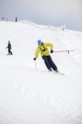 Hombre adulto en ropa de abrigo esquiando - foto de stock