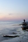 Человек рыбачит на закате, избирательный фокус — стоковое фото