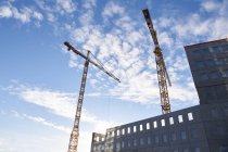 Low angle view of industrial cranes in city — Stock Photo