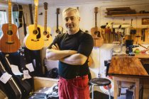 Портрет мастера в мастерской по изготовлению гитары, избирательный фокус — стоковое фото