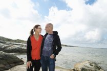 Mann und Frau stehen am Strand und schauen einander an — Stockfoto