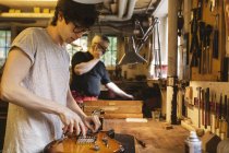 Craftsman working in guitar making workshop — Stock Photo