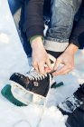 Vista cortada de mulheres que atam patins de gelo — Fotografia de Stock