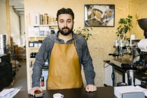 Small business owner looking at camera at coffee roaster shop — Stock Photo