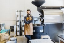 Small business owner with arms crossed at coffee roaster shop — Stock Photo