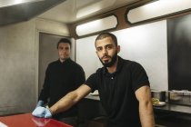 Workers in food truck, focus on foreground — Stock Photo